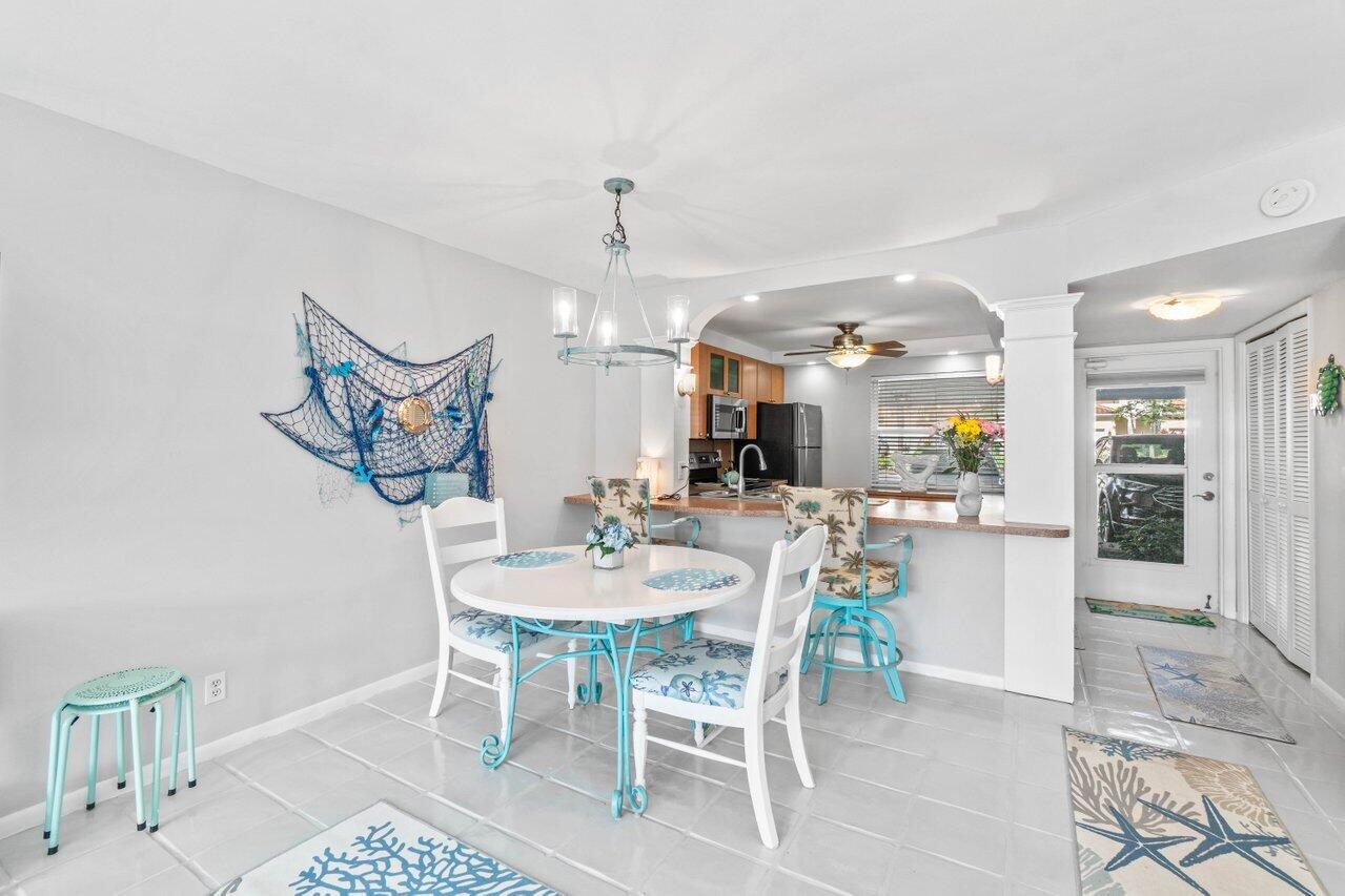 a kitchen with stainless steel appliances kitchen island granite countertop a table and chairs in it