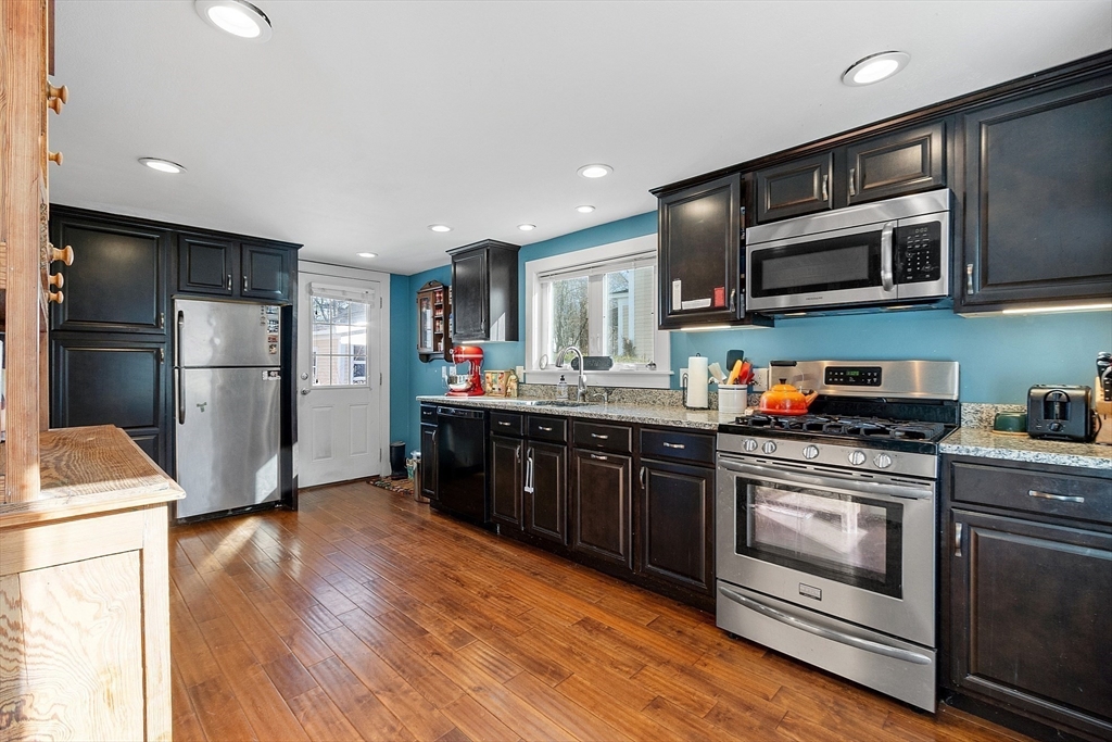 a kitchen with stainless steel appliances granite countertop a refrigerator stove and sink