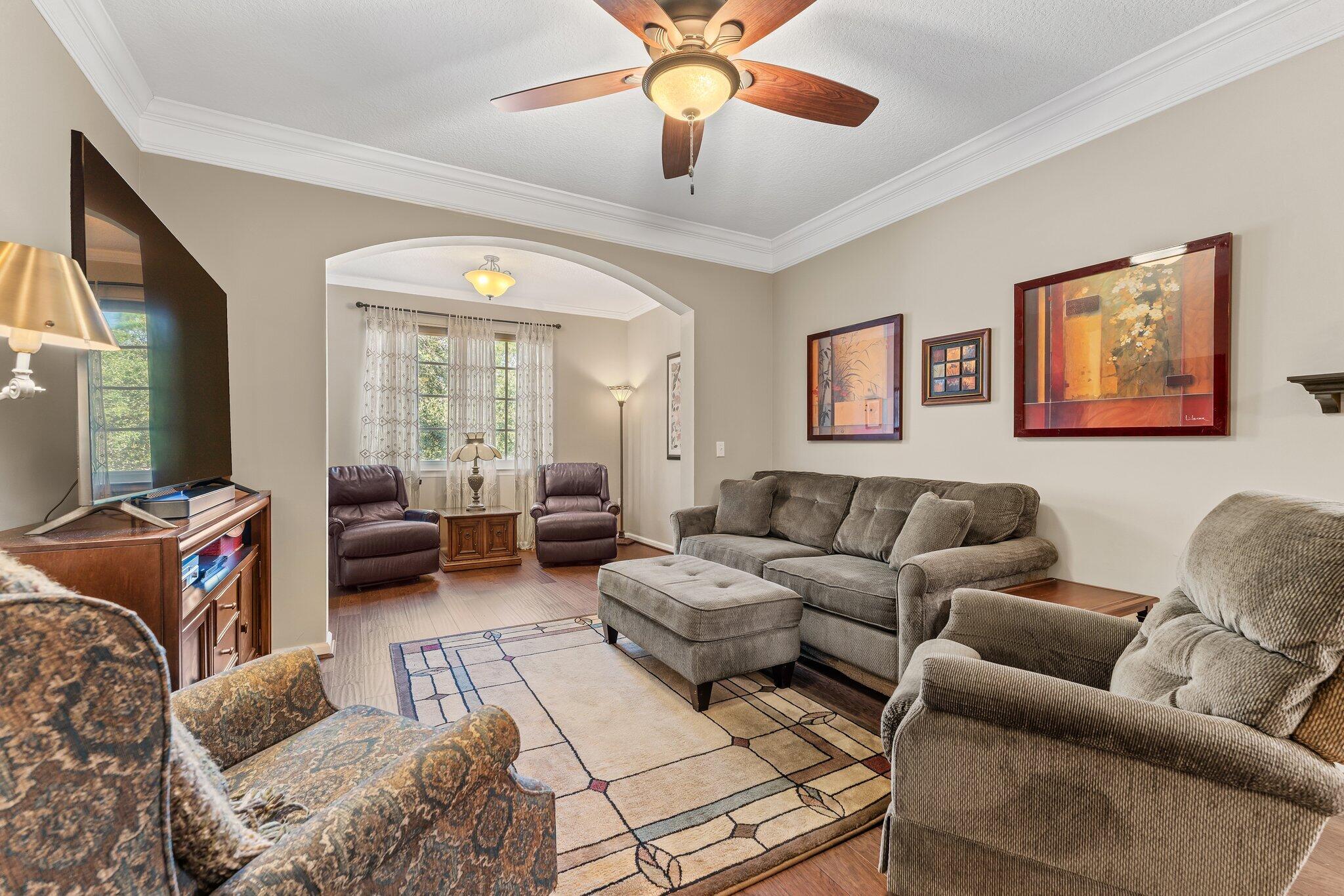 a living room with furniture ceiling fan and a rug