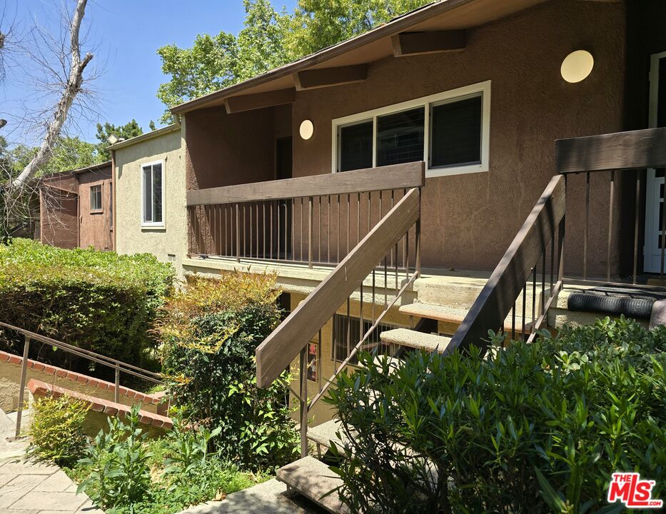 a balcony with wooden floor and stairs