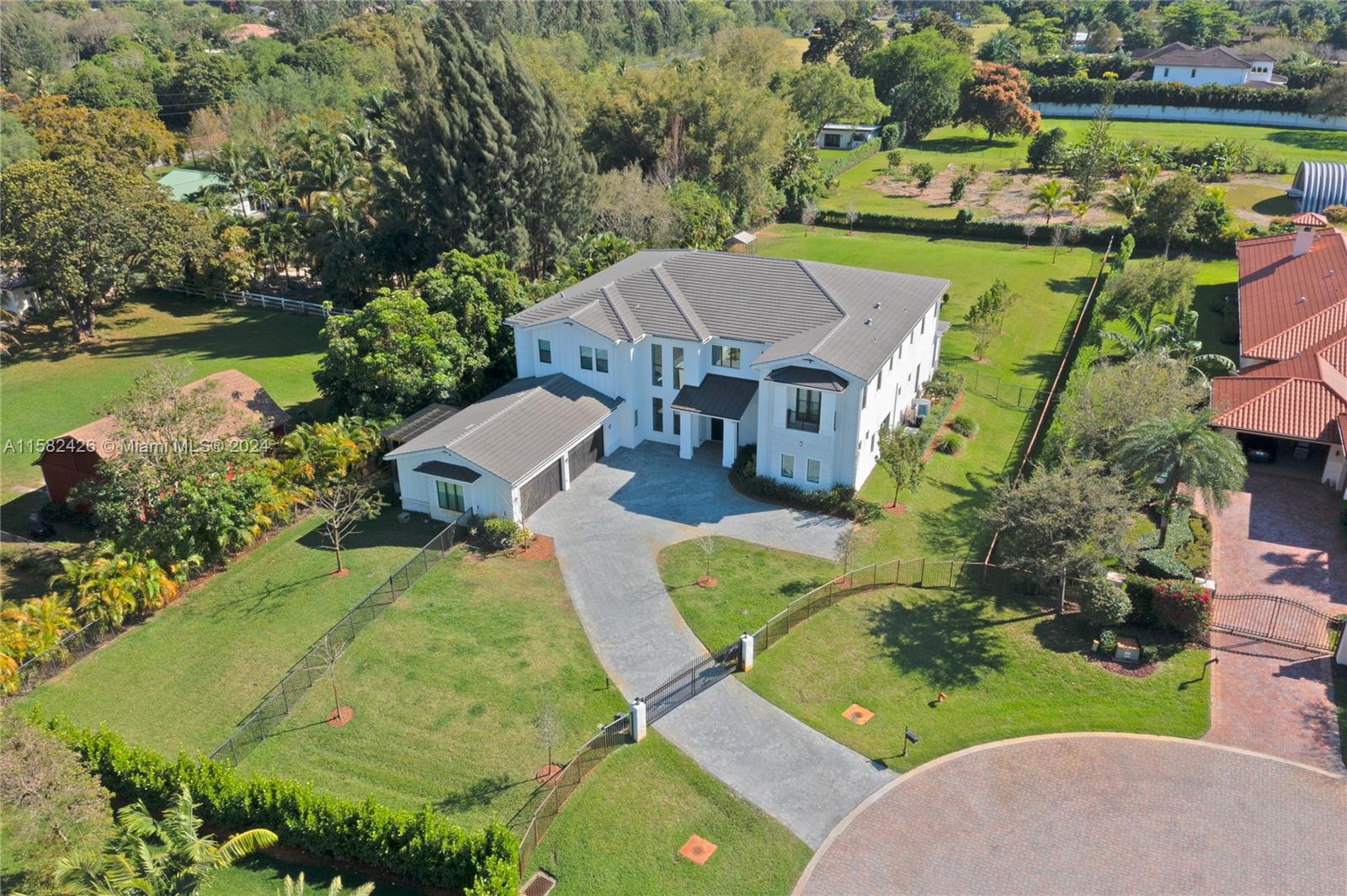 an aerial view of a house with a garden and lake view