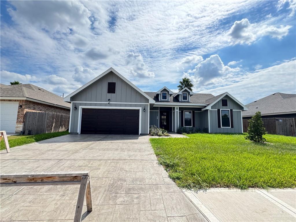 View of front of property featuring a front yard and a garage