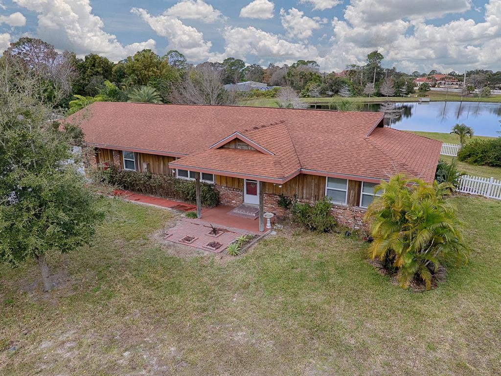 an aerial view of a house with a yard and lake view