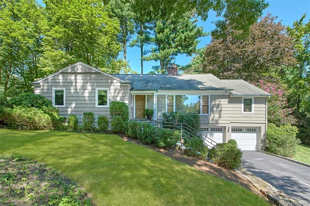 a front view of a house with a yard and trees