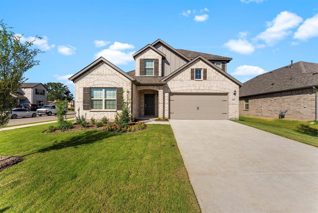 a front view of a house with a yard and garage