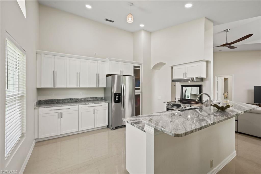 Kitchen with plenty of natural light, stainless steel appliances, ceiling fan, and white cabinetry