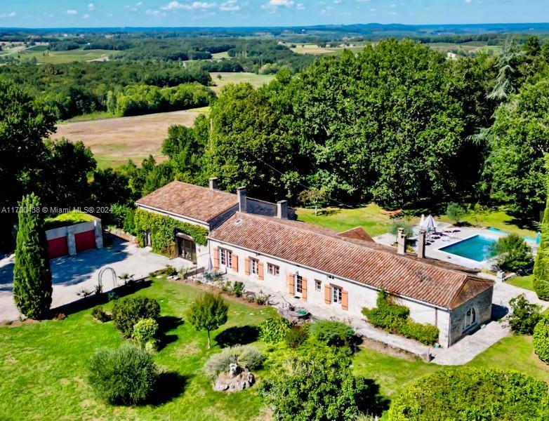 an aerial view of a house with a garden and lake view