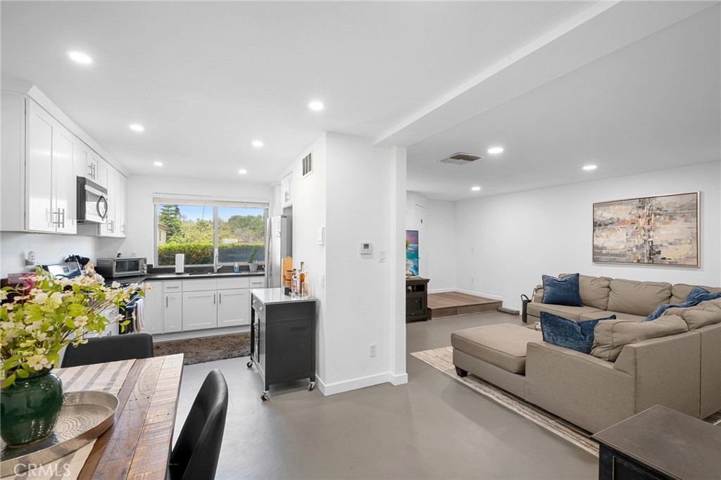 a living room with furniture and a dining table with kitchen view