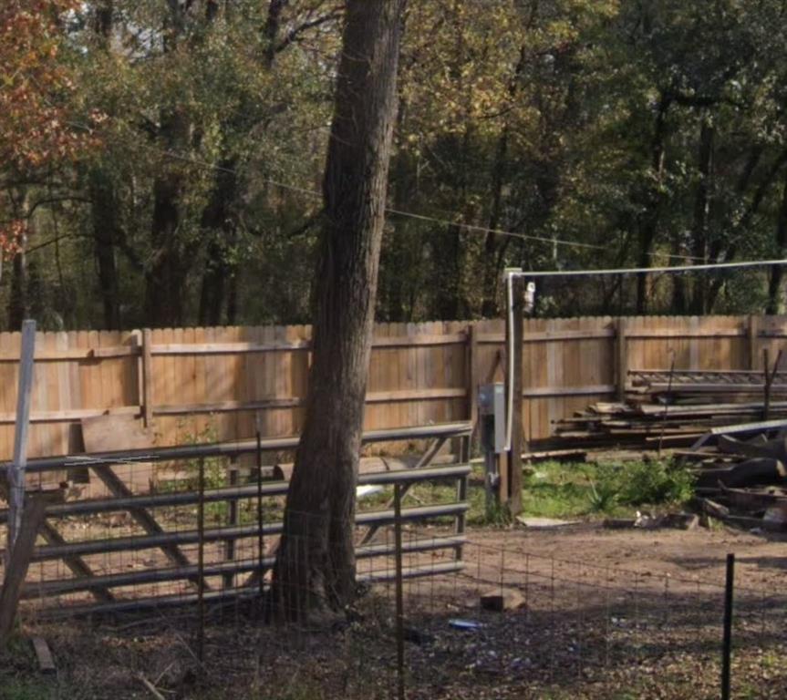 a backyard of a house with wooden fence and trees