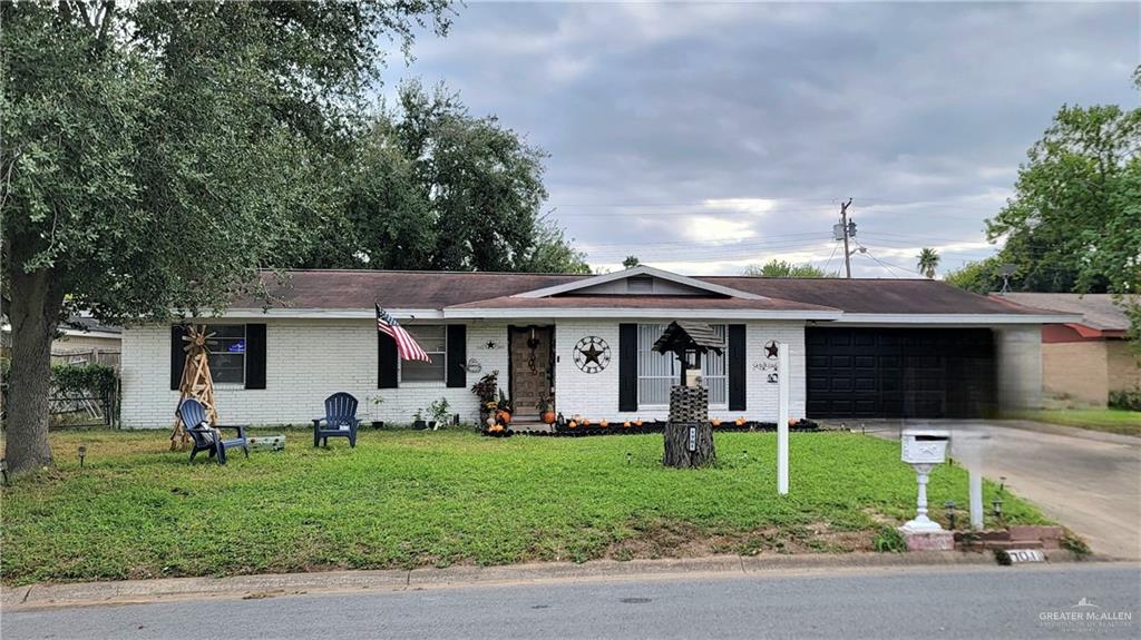 Ranch-style home with a front yard and a garage