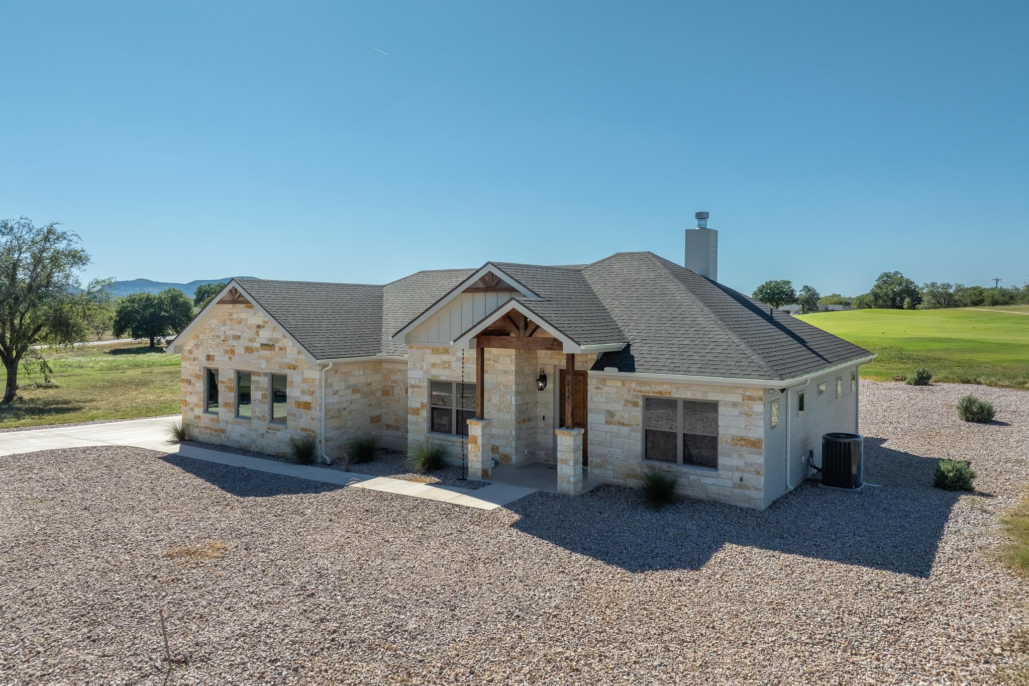 a front view of a house with a garden and yard