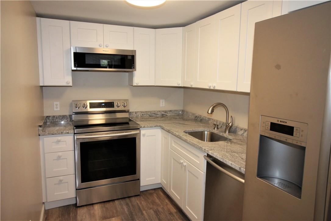 a kitchen with stainless steel appliances granite countertop a stove microwave and sink