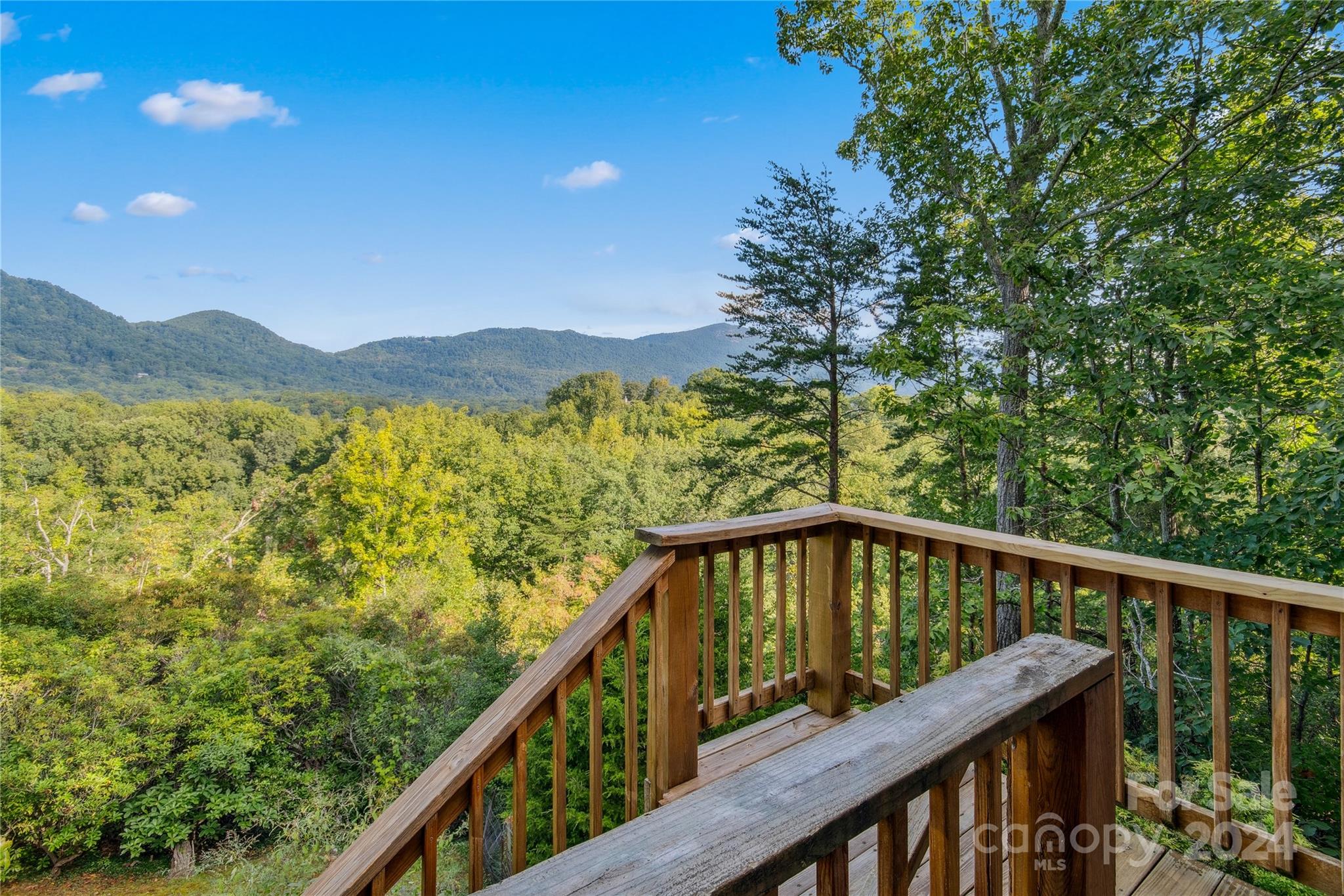 a view of a balcony with wooden floor and fence