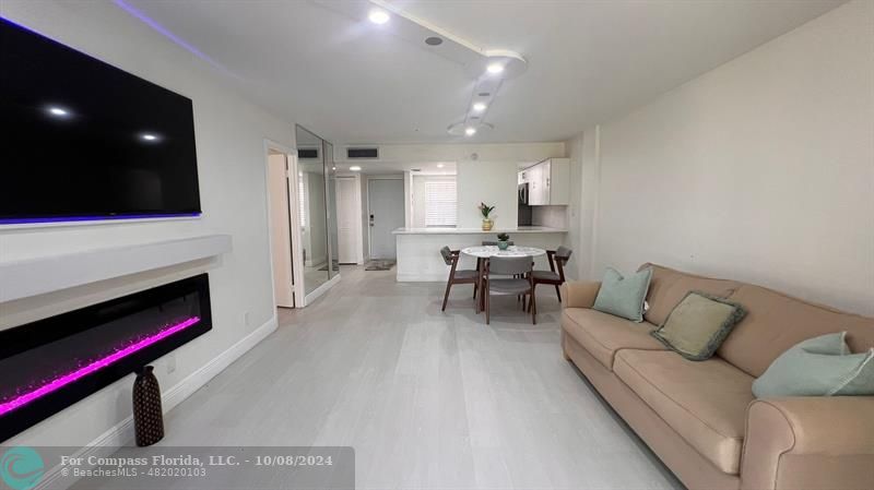 a living room with furniture and a fireplace with wooden floor