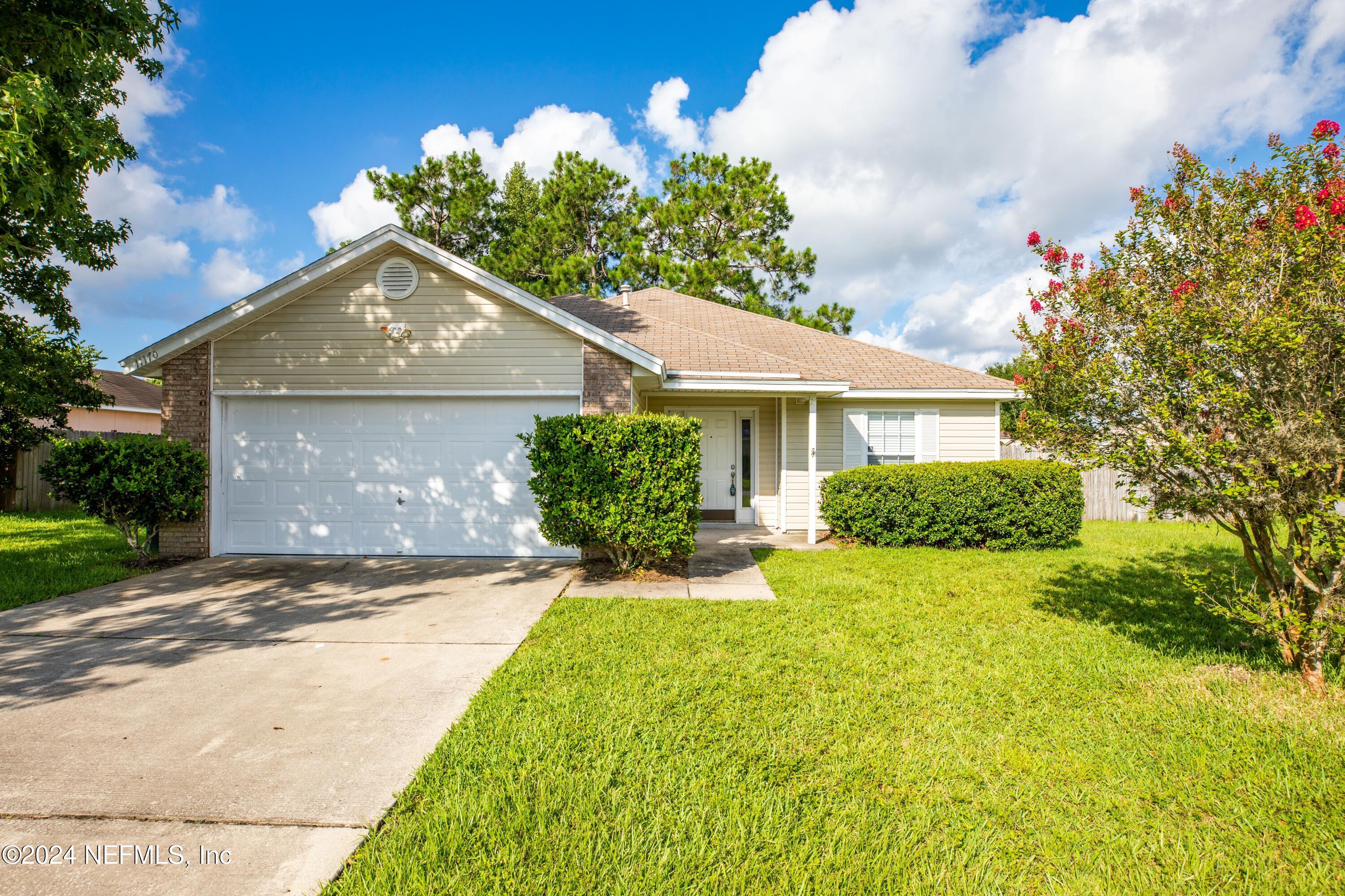 a front view of a house with a yard and garage