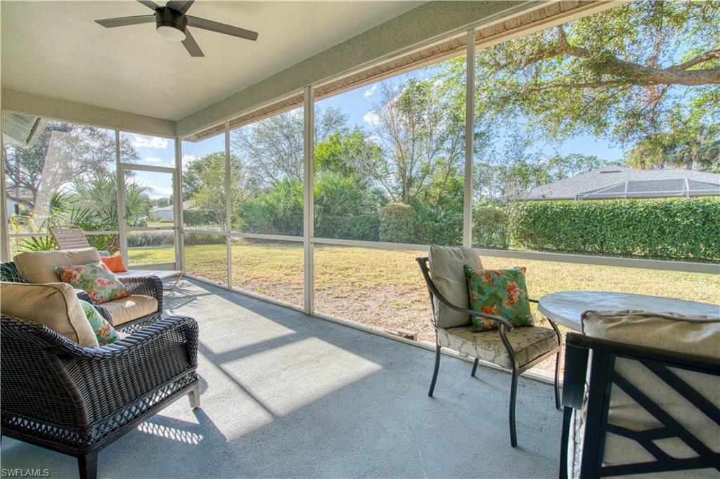 a living room with patio furniture and a floor to ceiling window