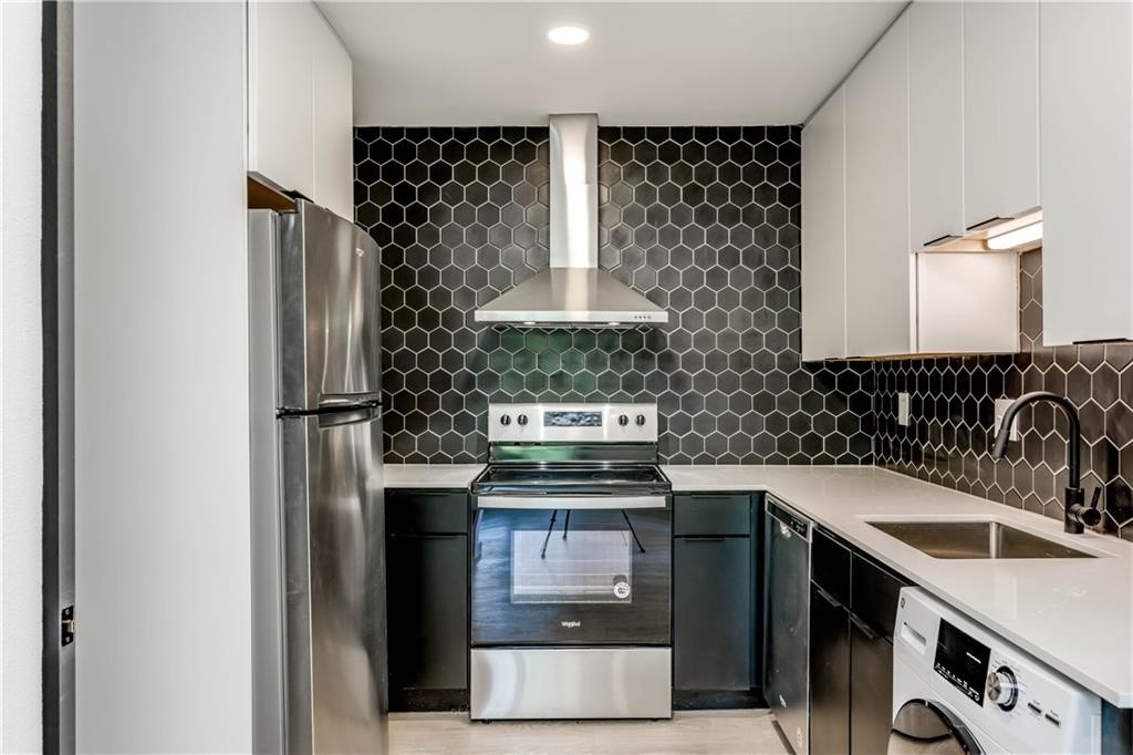 a kitchen with stainless steel appliances granite countertop a stove a refrigerator and a sink