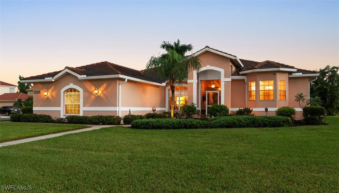 a front view of a house with a garden and yard