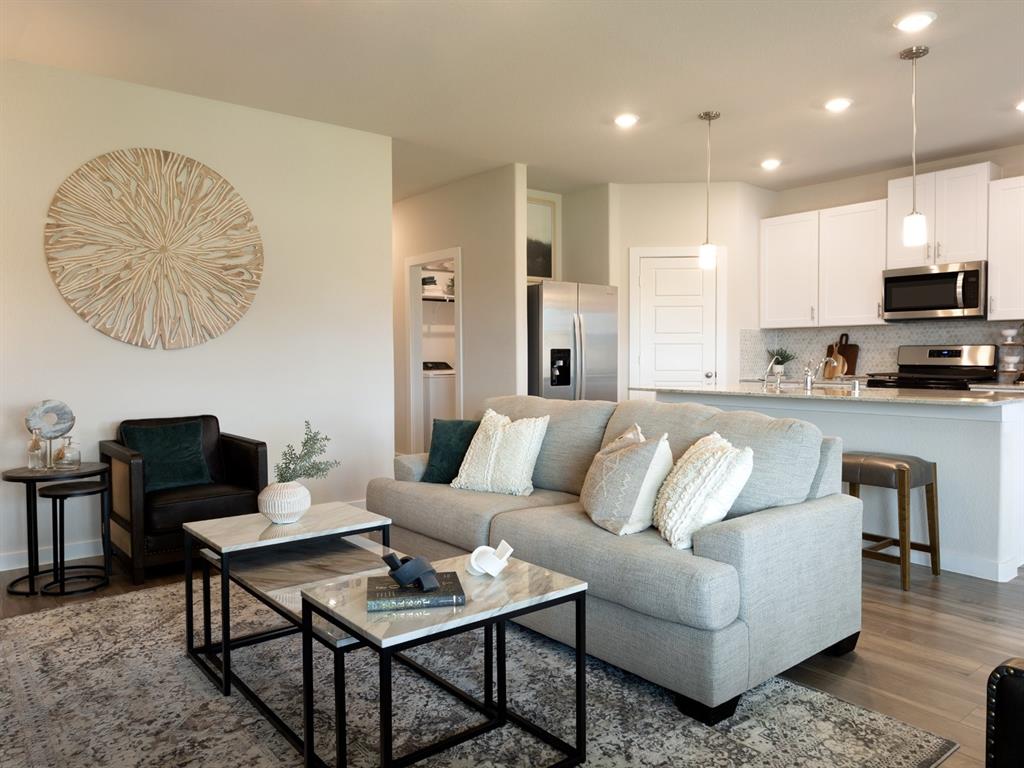 a living room with furniture a rug and a kitchen view