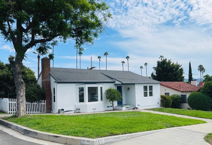 a front view of a house with a yard and trees