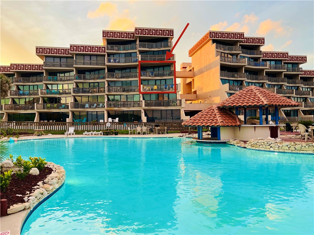 a view of a swimming pool with a yard and sitting area