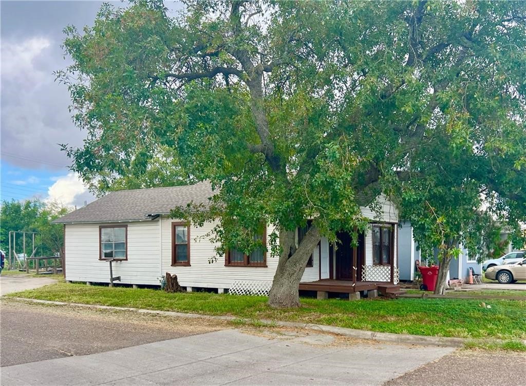 a front view of a house with a garden and trees