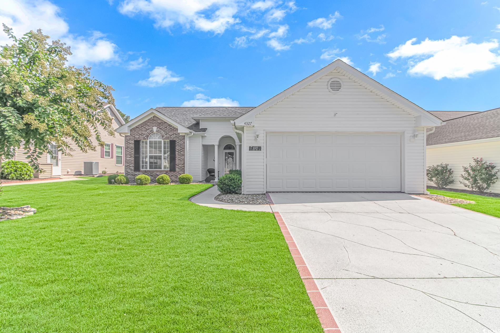 Ranch-style home featuring a garage, a front lawn,