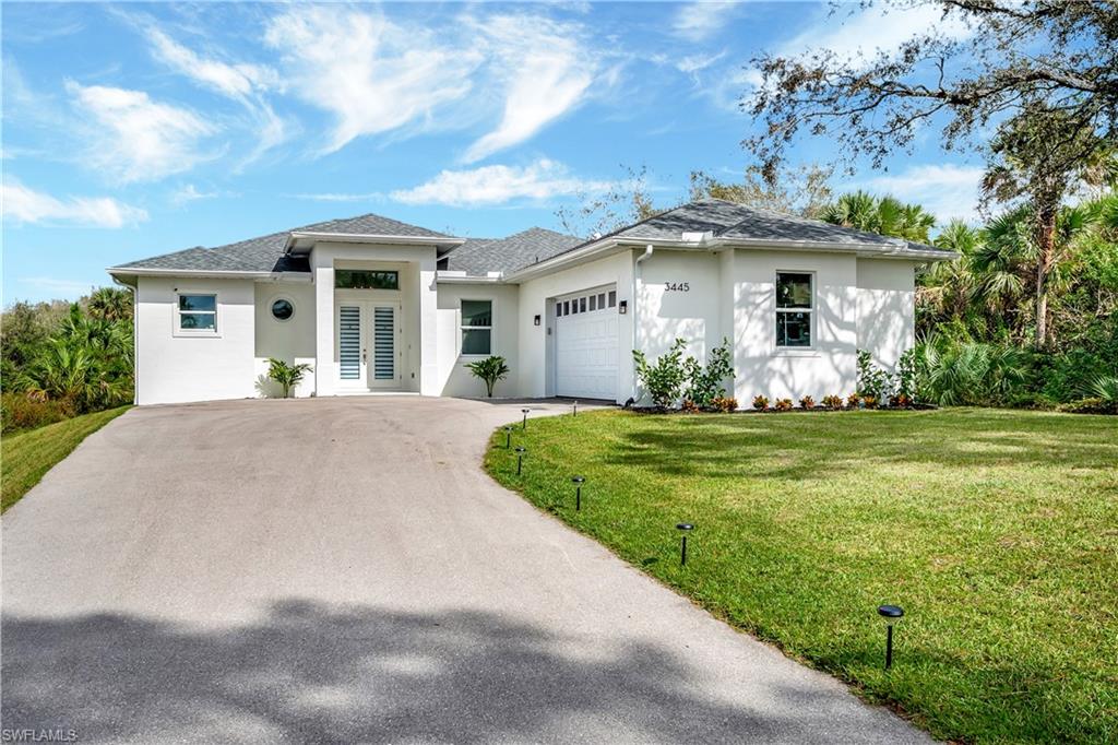 View of front of property featuring a front yard and a garage