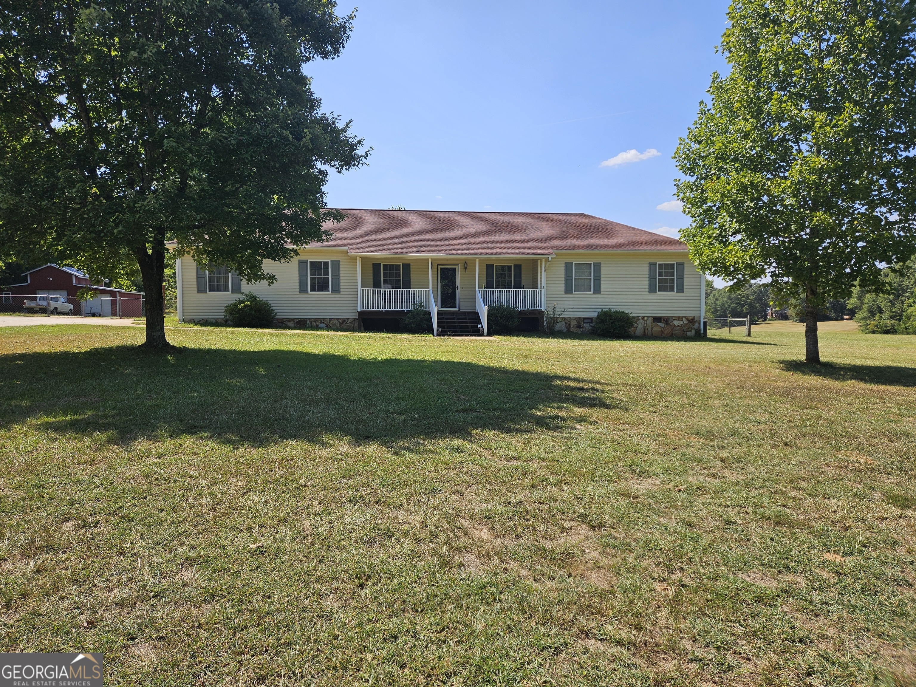 a view of an house with backyard and trees