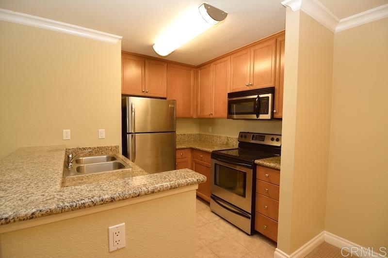 a kitchen with granite countertop a refrigerator and a sink