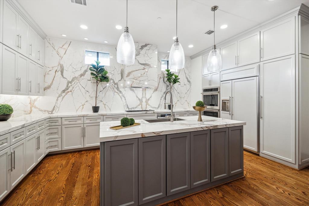 a kitchen with a sink a counter space appliances and cabinets