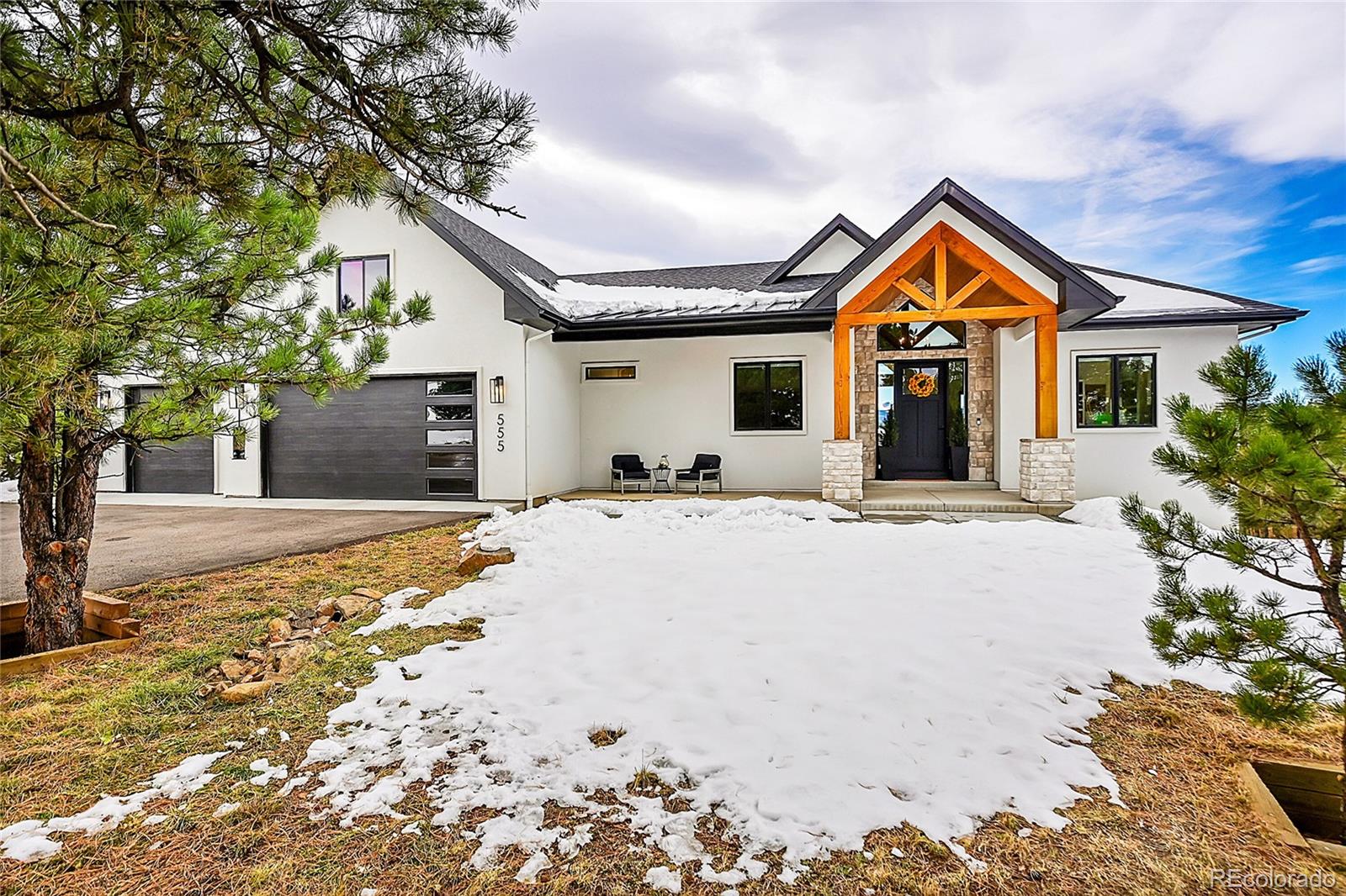 a front view of a house with yard and covered with snow