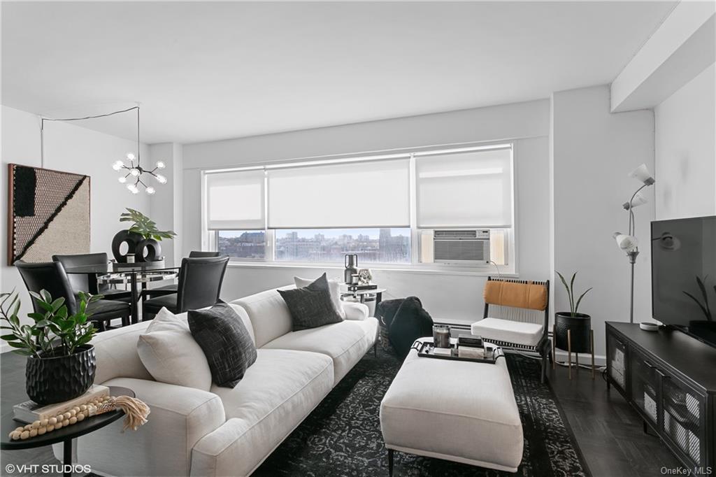 Living room with dark hardwood / wood-style floors and a notable chandelier