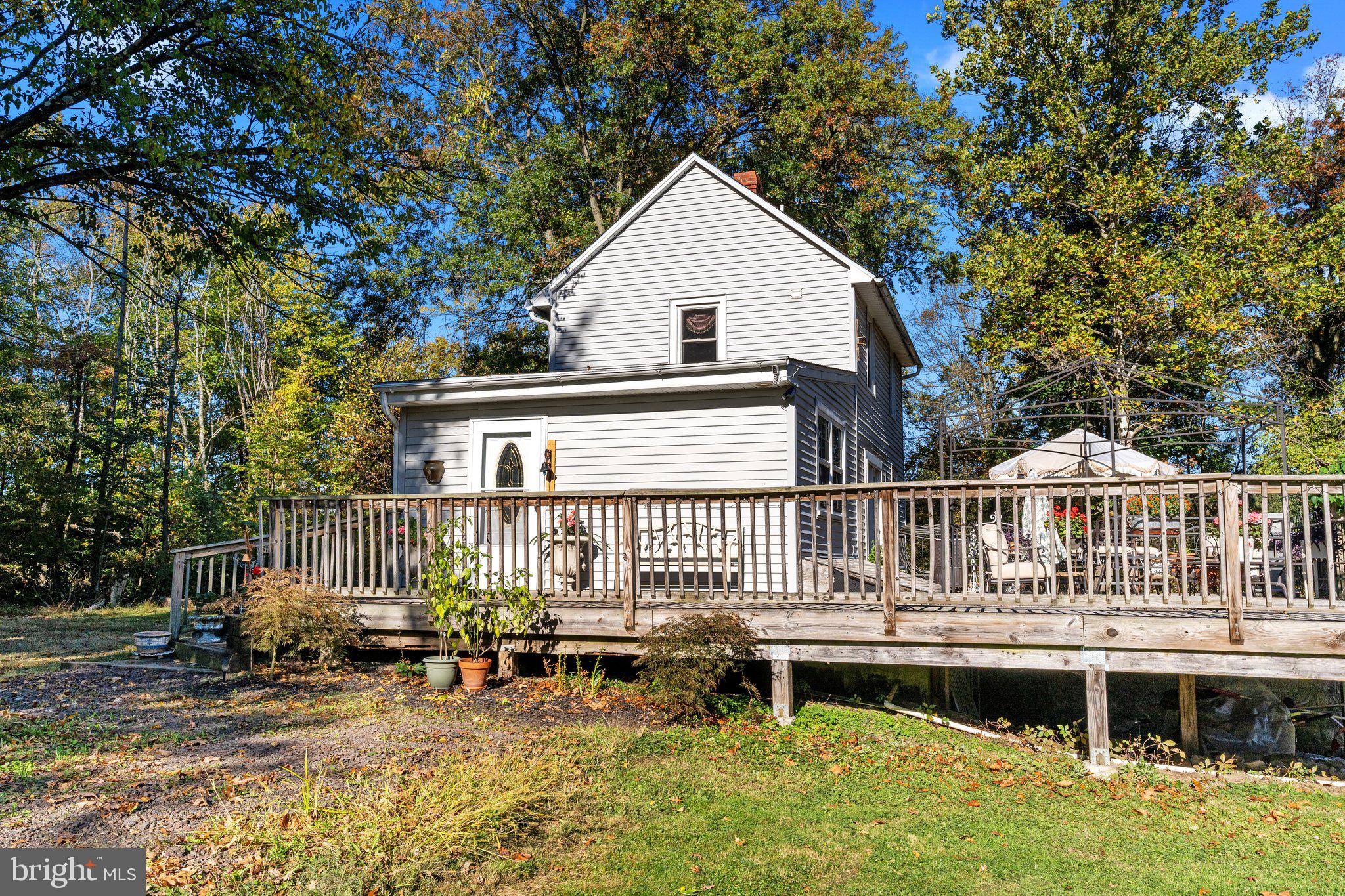 a view of a house with a wooden deck and furniture