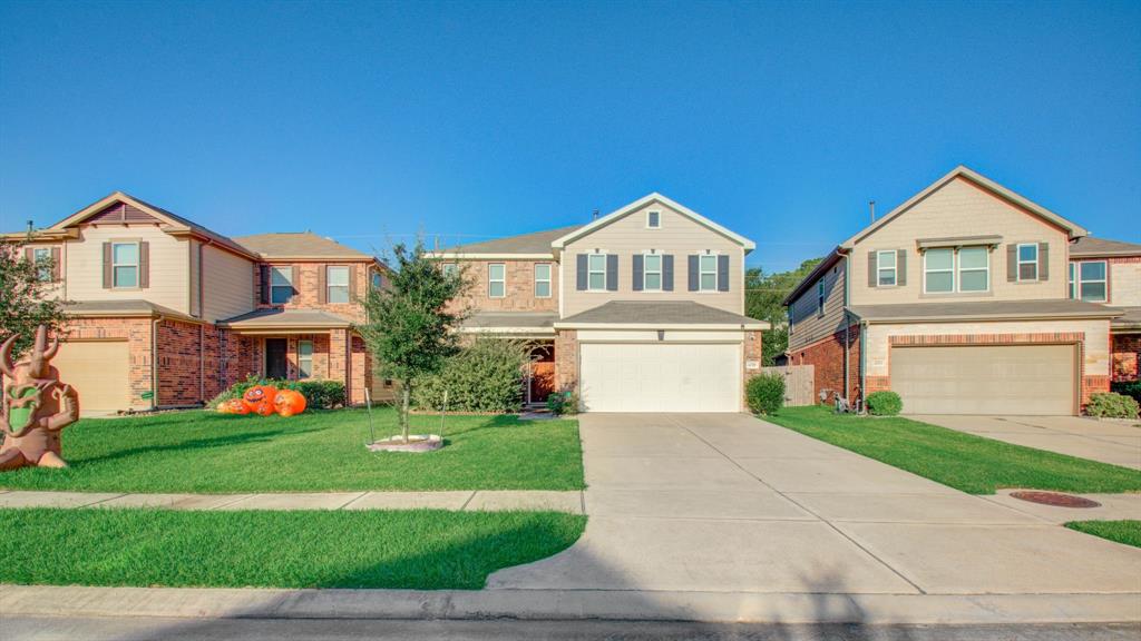 a front view of a house with a yard and garage