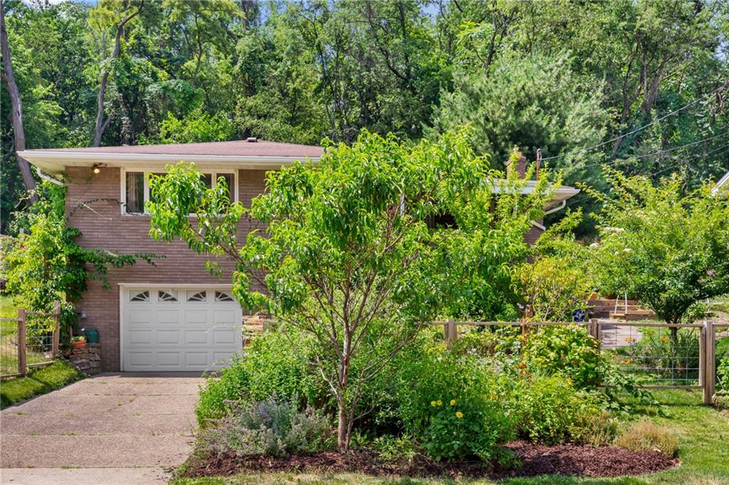 an aerial view of a house with a yard and tree s