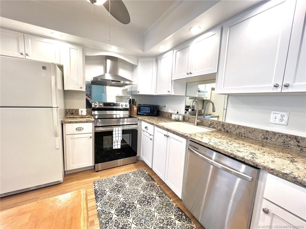 a kitchen with stainless steel appliances granite countertop a refrigerator sink and stove