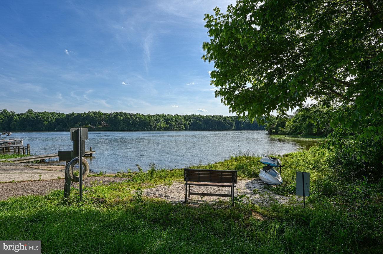 a view of a lake with a bench and trees around