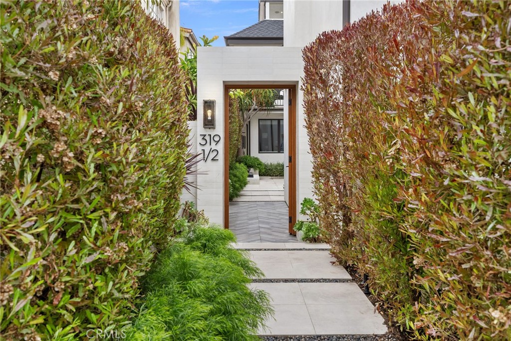 a pathway of a house with potted plants