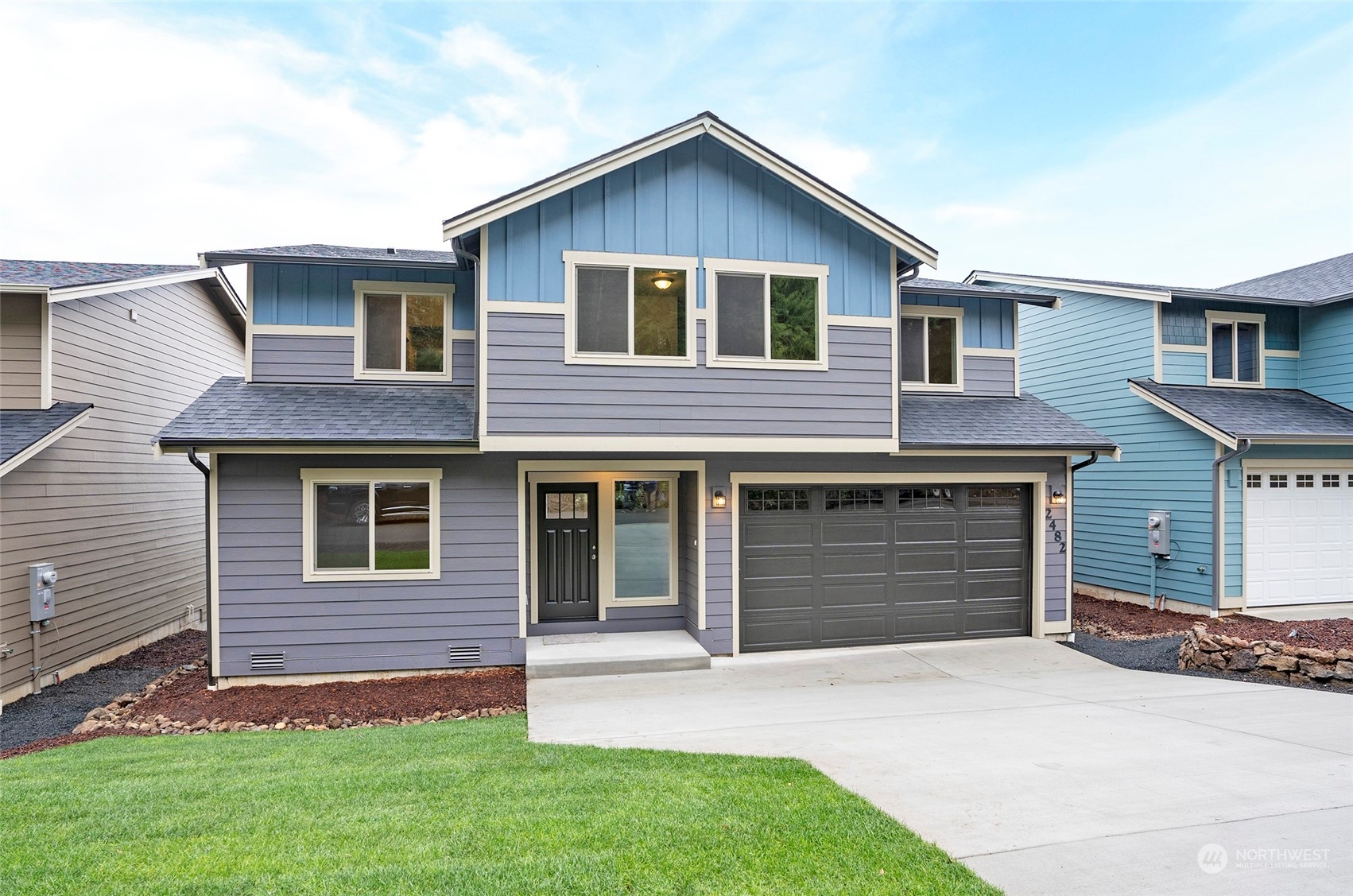 a front view of a house with a yard and garage