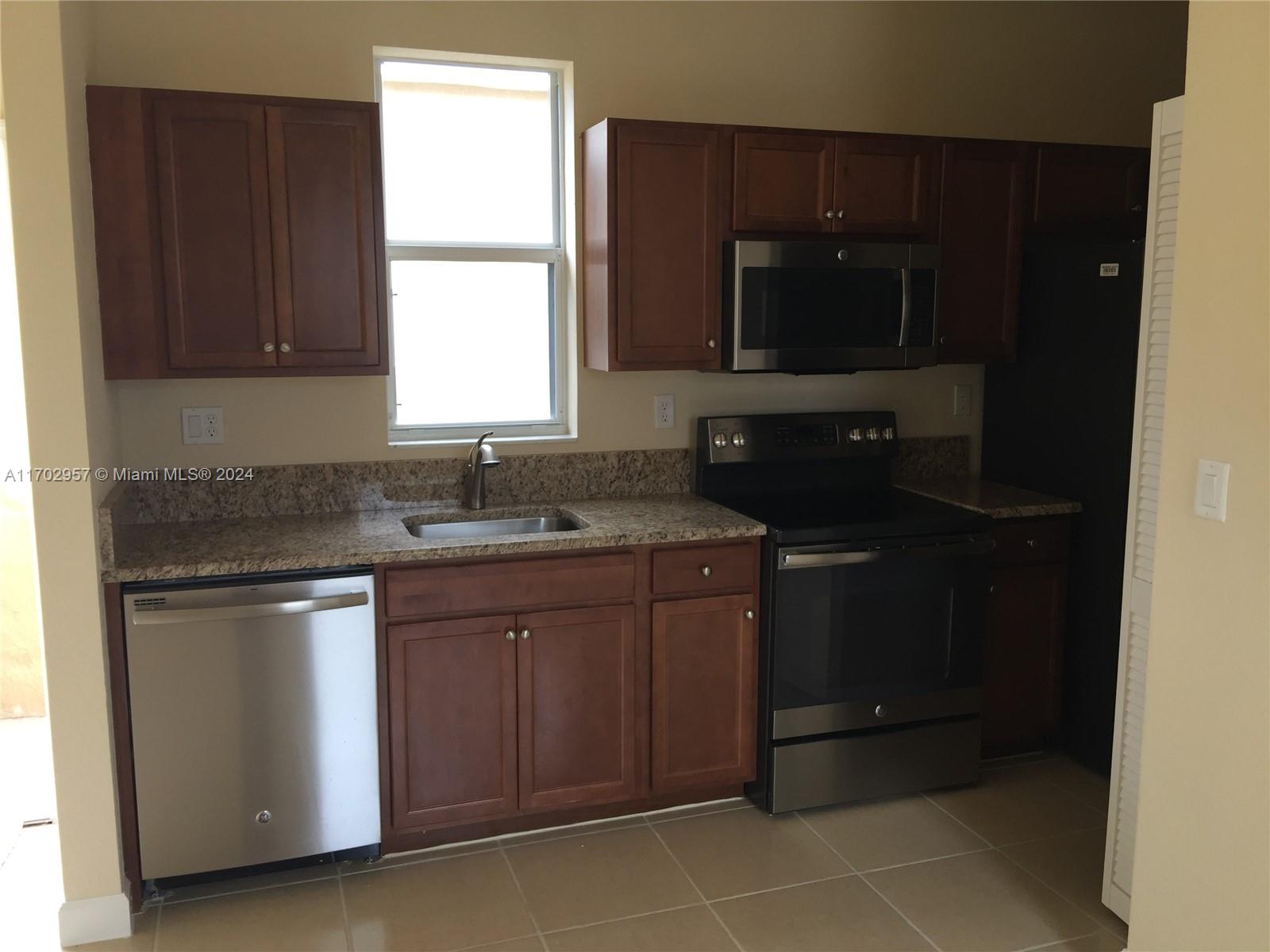 a kitchen with a sink a stove and a microwave