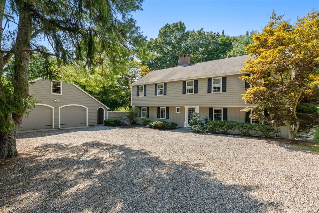 a front view of a house with a yard and trees