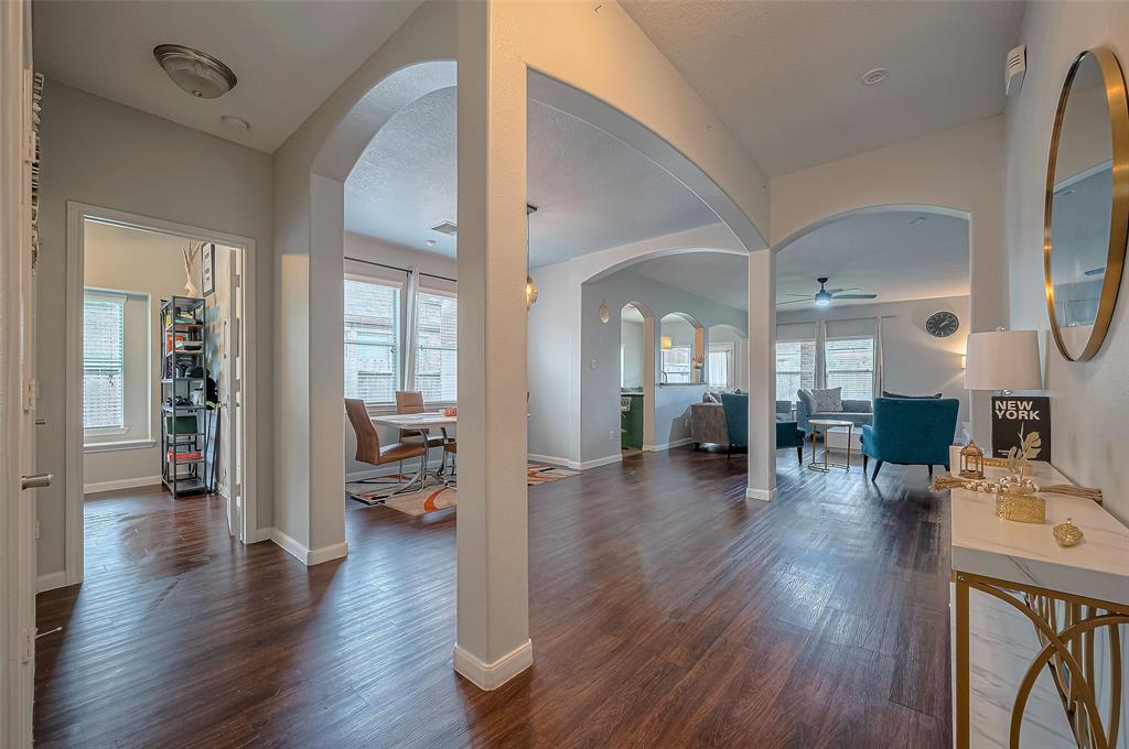 a view of a livingroom with furniture wooden floor and a way to kitchen