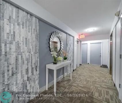 a view of a hallway with wooden floor and a living room