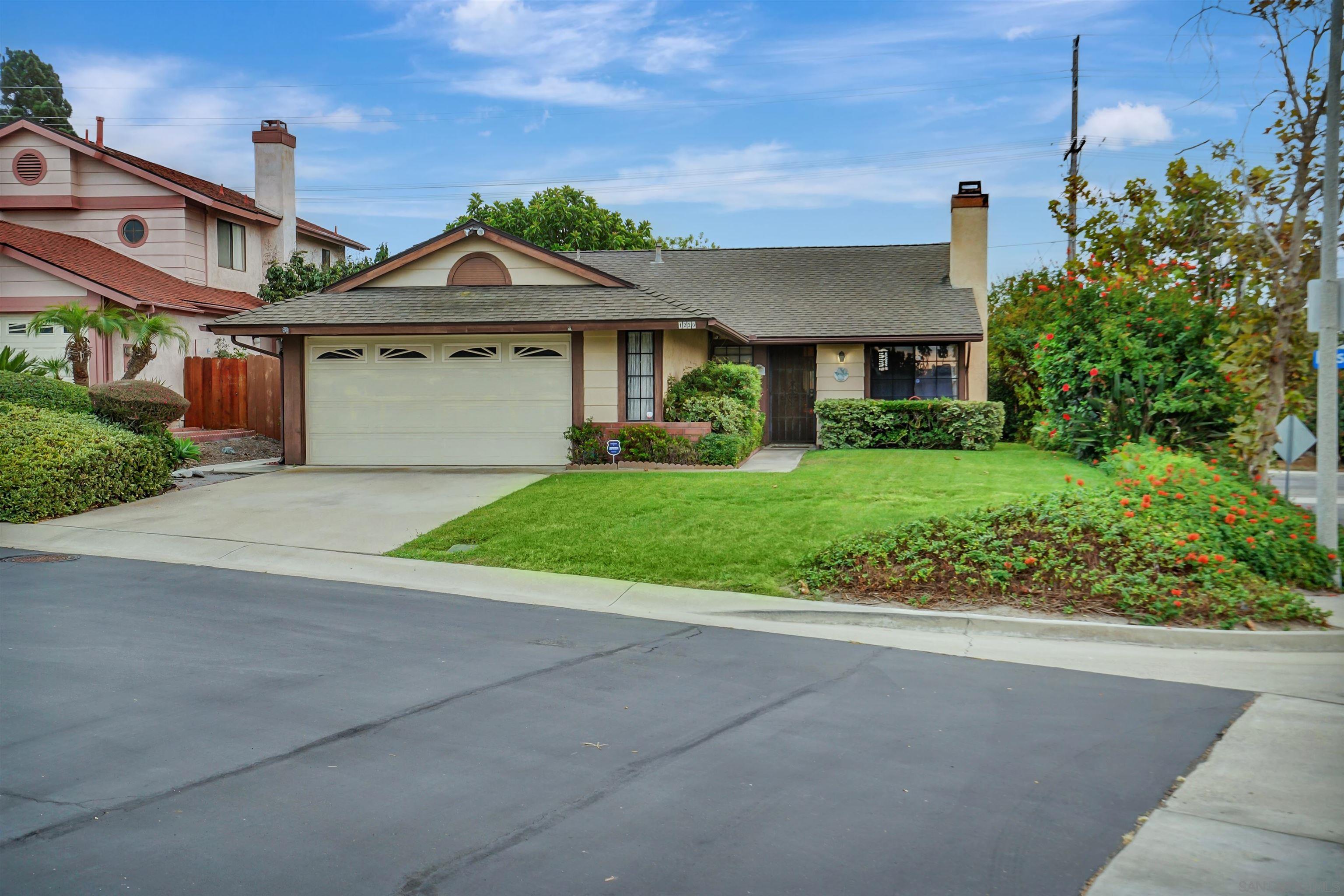 a front view of a house with a yard and potted plants