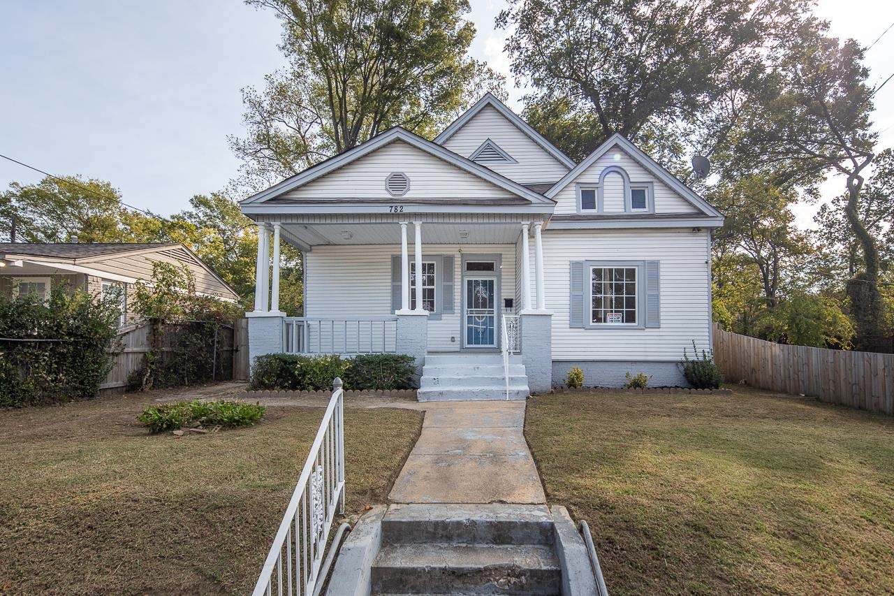 View of front of property with a porch and a front lawn