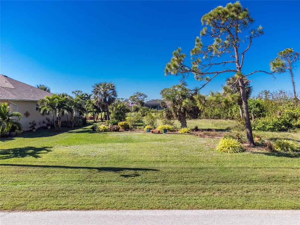 a view of a big yard with an ocean view