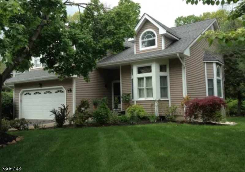 a front view of a house with a garden and plants