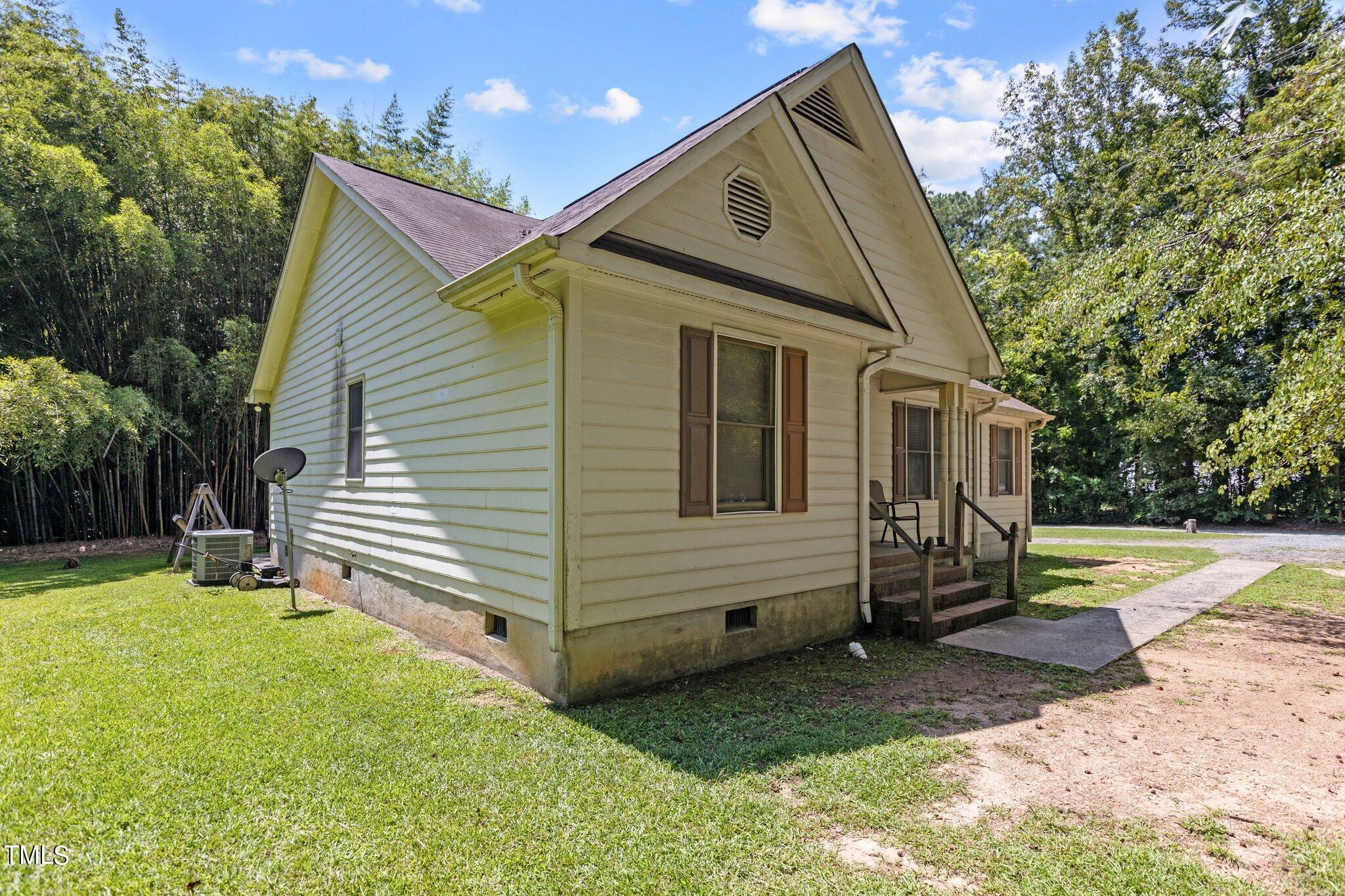 a view of a house with backyard and trees