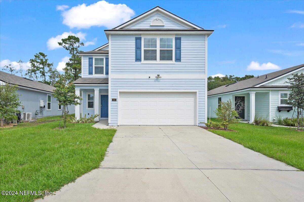 a front view of a house with a yard and garage